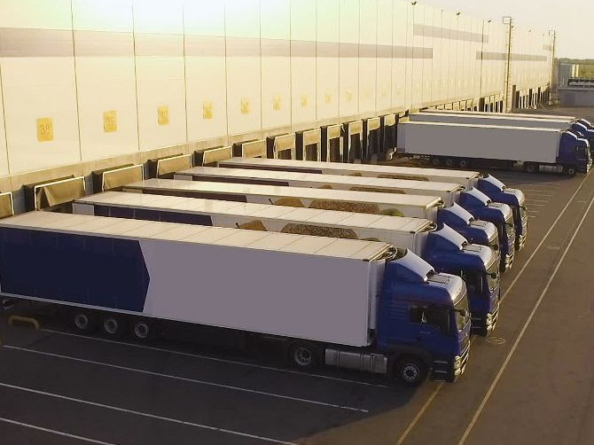 A row of trailers backed onto the dock doors of a distribution centre