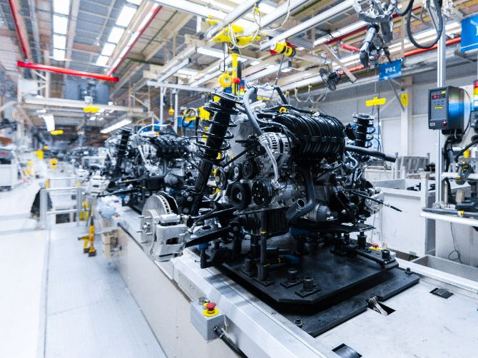 An engine on an automotive assembly line surrounded by line-side parts
