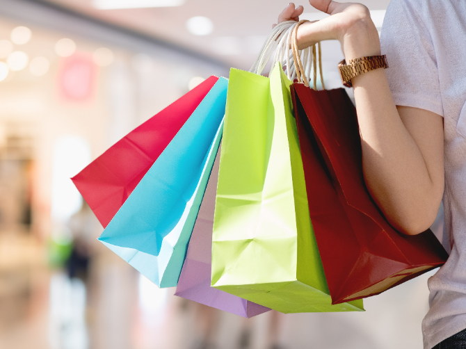 A shopper carrying bags from several stores